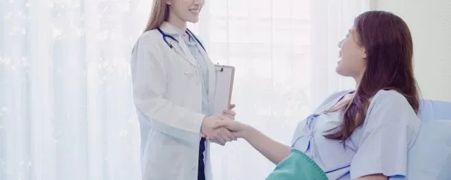 Doctor Shaking Hands With Patient In Hospital Room
