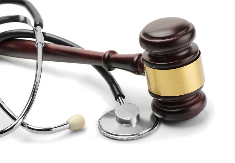 Close up of stethoscope and gavel on white background
