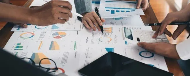 Team Analyzing Business Data and Charts on Paper