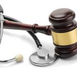 Close up of stethoscope and gavel on white background Close up of stethoscope and gavel on white background