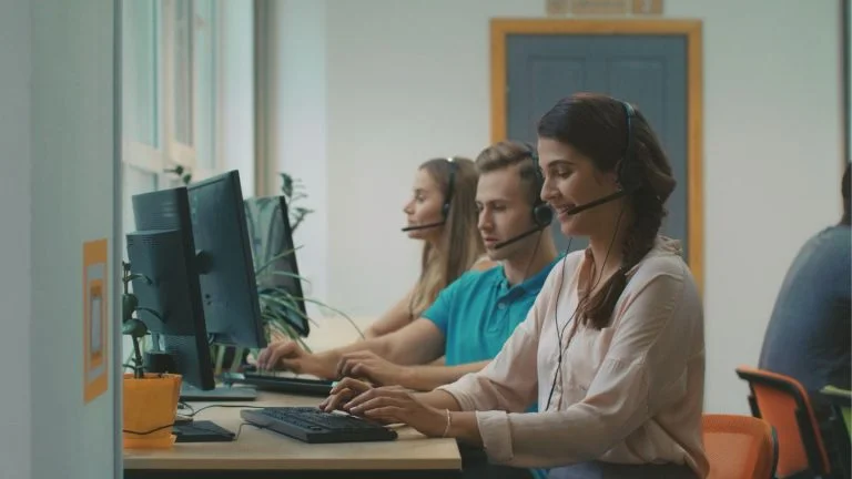 Call Center Team Working at Desks with Headsets