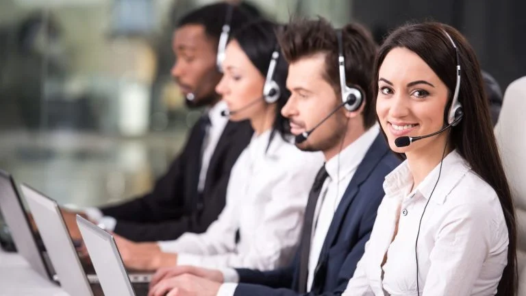 Customer Service Team Working with Headsets on Computers
